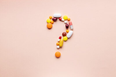 medicine pills question mark symbol isolated over pink background. medical decision concept.